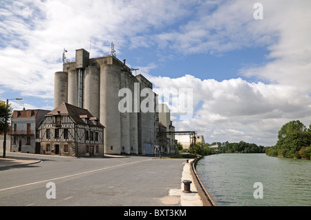 Riesigen Getreidesilos auf dem Fluss Seine Zwerg traditionelle Gebäuden auf dem Quai De La Gare in Bray-Sur-Seine-Nord-Zentral-Frankreich Stockfoto