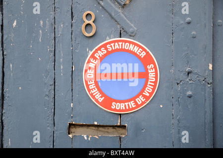 Kein Parkplatz-Schild auf Nummer 8 alte hölzerne Garagentor lesen Priere de Ne Pas Stationner in Crepy-En-Valois Frankreich Stockfoto