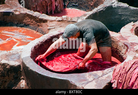 Arbeiter im roten Farbstoff MwSt färben Tier verstecken, um in Hausschuhe (Babouche) im berühmten Gerbereien in Fes, Marokko gemacht werden Stockfoto