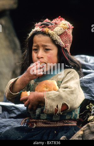 Zerlumpten Quechua Mädchen essen Brot, Willoq, Peru Stockfoto