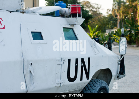 Ein UN-Fahrzeug und Soldaten Gewährung von Schutz für eine humanitäre Hilfsorganisation verteilen Lebensmittel in Haiti. Stockfoto
