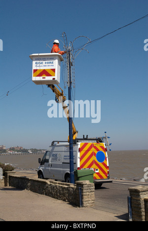 Mann auf Hubarbeitsbühnen Überprüfung am Meer Lichter Felixstowe Suffolk UK Stockfoto