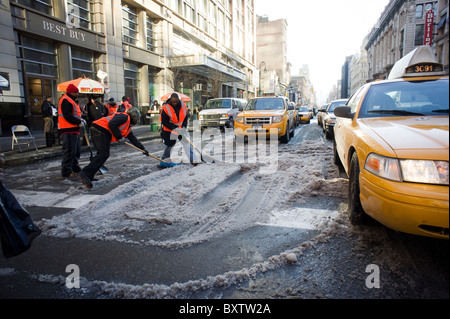 Arbeitnehmer, die von der Stadt gemietet auszugraben Schnee auf die Straßen im Stadtteil Chelsea in New York zu löschen Stockfoto