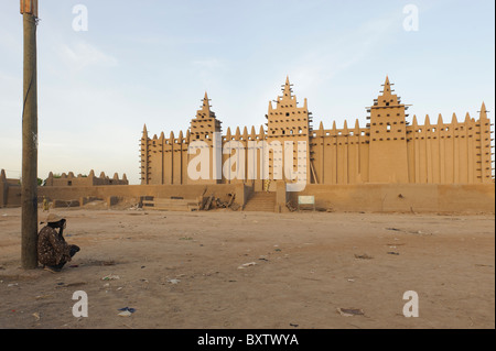 Man lehnte sich gegen einen Laternenpfahl und hören bei einem Transistorradio Basislohn große Moschee von Djenné, Mali, in den frühen Morgenstunden Stockfoto