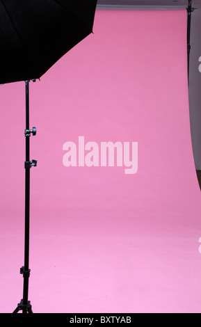 Rosa Fotostudio Hintergrund mit Regenschirm auf einem Ständer Stockfoto