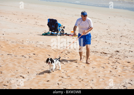 Mann mittleren Alter geht sein Haustier English Springer Spaniel am Strand von Beverly Beach, Florida Stockfoto