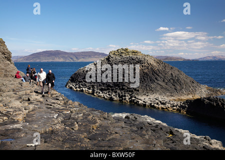 Touristen und polygonale Basalt, Am Buachaille Felsen, Staffa aus Isle of Mull (in der Ferne), Schottland, Vereinigtes Königreich Stockfoto