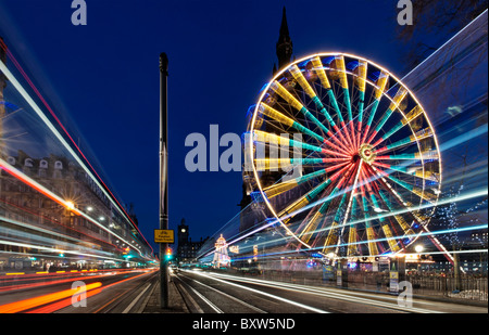 Das Edinburgh Rad vor das Scott Monument mit unscharfen Verkehr auf Princes Street, Edinburgh, Scotland, UK. Stockfoto