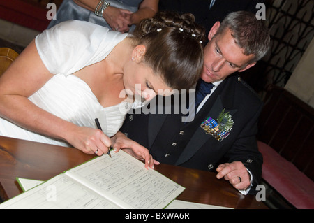 Horizontale Nahaufnahme Portrait einer Braut und Bräutigam das offizielle Register ihre traditionelle kirchliche Trauung nach Unterzeichnung. Stockfoto