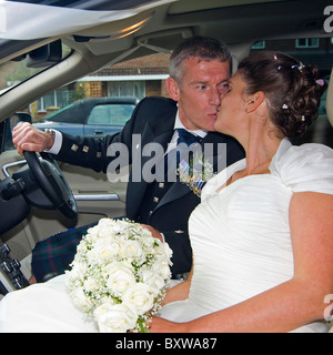 Platz in der Nähe bis Porträt einer Braut und Bräutigam küssen in einem Auto. Stockfoto