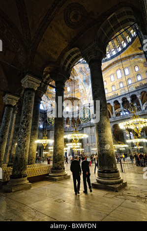 Hagia Sophia Interior Istanbul Türkei // ISTANBUL, Türkei — die große Haupthalle der Hagia Sophia zeigt ihre bemerkenswerte byzantinische Architektur mit ihrer massiven zentralen Kuppel, die von Pendentiven und Halbkuppeln gestützt wird. Das Innere zeigt sowohl christliche als auch islamische Elemente, darunter byzantinische Mosaike, osmanische Kalligrafie und große osmanische Vogelleuchter. Massive Marmorsäulen und -Tafeln säumen den Raum und demonstrieren die Pracht der architektonischen Technik aus dem 6. Jahrhundert. Stockfoto