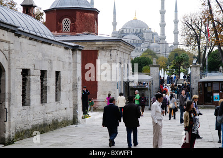 Hagia Sophia Courtyard Touristen Istanbul Türkei // ISTANBUL, Türkei — mit Sultanahmet im Hintergrund versammelten sich Touristen im Innenhof der Hagia Sophia. Ursprünglich als christliche Kathedrale erbaut, dann im 15. Jahrhundert in eine muslimische Moschee umgewandelt und heute (seit 1935) ein Museum, ist die Hagia Sophia eines der ältesten und großartigsten Gebäude Istanbuls. Tausend Jahre lang war sie die größte Kathedrale der Welt und gilt als Krönung der byzantinischen Architektur. Stockfoto
