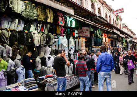 Grand Bazaar Kleidungsladen Istanbul | ISTANBUL, Türkei — Menschenansammlungen versammeln sich vor einem Kleidungsgeschäft, das die äußere Umgrenzung des Großen Basars von Istanbul säumt, wo sich der Einzelhandel über die Jahrhunderte hinaus über die ursprünglichen gewölbten Bedesten-Hallen erstreckte, als sich der Handel ausweitete. Die äußere Kante des Marktes wurde nach dem Erdbeben von 1894 neu geformt, als die Behörden seinen Umfang reduzierten und offene Dolap-Stände durch Schaufenster im westlichen Stil ersetzten. Stockfoto
