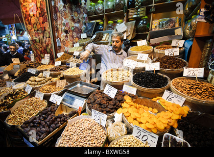 ISTANBUL, Türkei / Türkiye — Ein Händler, der getrocknete Früchte und Nüsse auf dem Gewürzbasar (auch bekannt als ägyptischer Basar) in Istanbul, Türkei, verkauft. Stockfoto