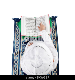 Muslimische Junge liest den Koran Stockfoto