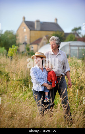 Eine Familie auf ihre Kleinfarm mit einem Folientunnel gemeinsamen Bauernhof Blumen UK Stockfoto