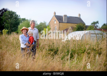 Eine Familie auf ihre Kleinfarm mit einem Folientunnel gemeinsamen Bauernhof Blumen UK Stockfoto