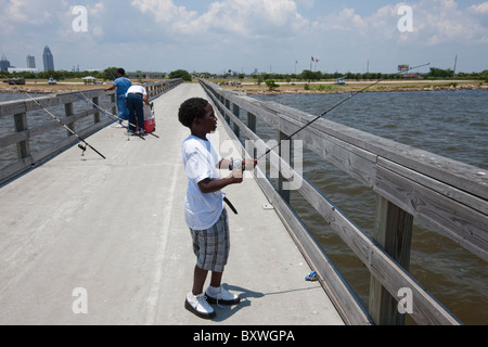 USA, Alabama, Mobile, afrikanisch-amerikanischer Junge in der Mobile Bay an Sommernachmittagen Angeln Stockfoto