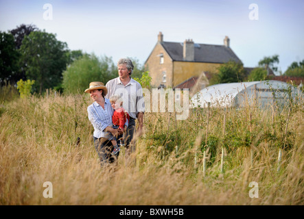 Eine Familie auf ihre Kleinfarm mit einem Folientunnel, gemeinsamen Bauernhof Blumen UK Stockfoto