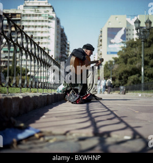 Eine männliche Straßenmusikant Gitarre zu spielen, in Buenos Aires Capital Federal, Argentinien Stockfoto