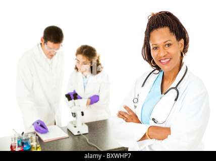 Afrikanisch-amerikanischen Ärztin mit Labor-Techniker im Hintergrund. Isoliert auf weiss. Stockfoto