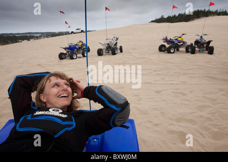 USA, Oregon, North Bend, Becky Selba ruht während der Fahrt ihr ATV auf Sanddünen am Oregon Dunes National Recreation Area Stockfoto