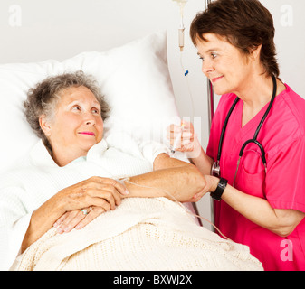 Krankenschwester verleiht eine ältere Krankenhauspatient Injektion. Stockfoto