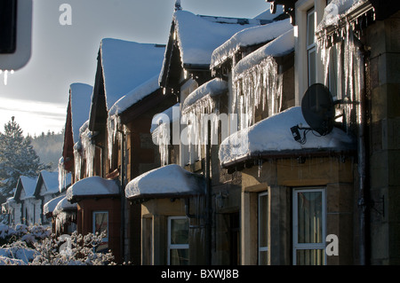 Eiszapfen hängen von Dächern nach Kälteeinbruch Stockfoto