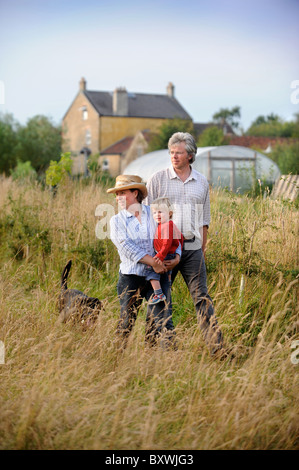 Eine Familie auf ihre Kleinfarm mit einem Folientunnel gemeinsamen Bauernhof Blumen UK Stockfoto