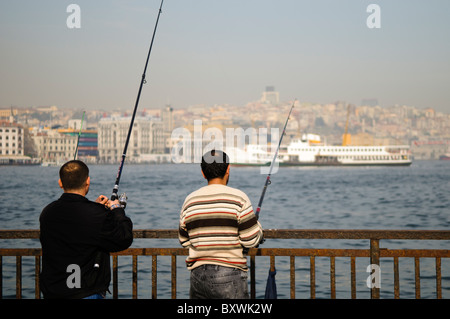 ISTANBUL, Türkei – lokale Fischer säumen das Geländer der historischen Galata-Brücke, die das Goldene Horn überspannt. Die Brücke, die Eminonu mit Karakoy verbindet, ist seit Generationen ein beliebter Angelplatz. Dutzende Angler versammeln sich routinemäßig entlang der oberen Ebene der Brücke, um ihre Linien in die Gewässer unter ihnen zu werfen. Stockfoto