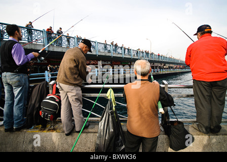 ISTANBUL, Türkei – lokale Fischer säumen das Geländer der historischen Galata-Brücke, die das Goldene Horn überspannt. Die Brücke, die Eminonu mit Karakoy verbindet, ist seit Generationen ein beliebter Angelplatz. Dutzende Angler versammeln sich routinemäßig entlang der oberen Ebene der Brücke, um ihre Linien in die Gewässer unter ihnen zu werfen. Stockfoto