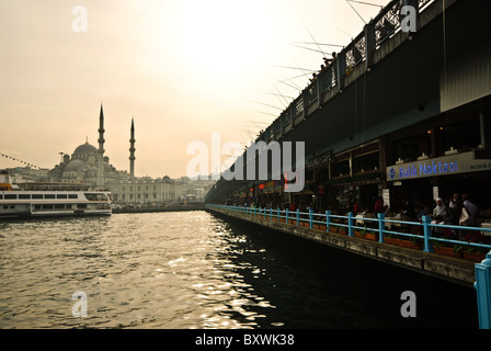 ISTANBUL, Türkei / Türkiye – Hidayet Cami in Eminonu, von der Galata-Brücke am späten Nachmittag aus gesehen. Reihen von Fischern Stockfoto