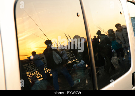 ISTANBUL, Türkei / Türkiye — Sonnenuntergang Reflexion auf einem Autofenster von Fischern auf der Galata-Brücke und einer Moschee auf der Skyline. Stockfoto