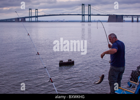 USA, New Jersey, Mann Angeln Wels in der Nähe von Delaware Memorial Bridge Delaware River an bewölkten Frühlingsabend Stockfoto