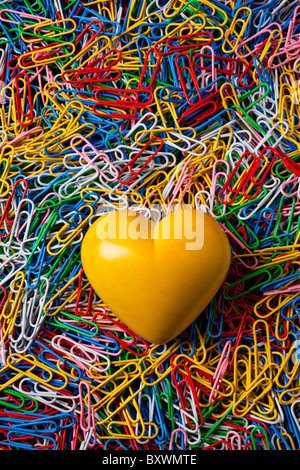 Gelber Stein Herz auf Büroklammern Stockfoto