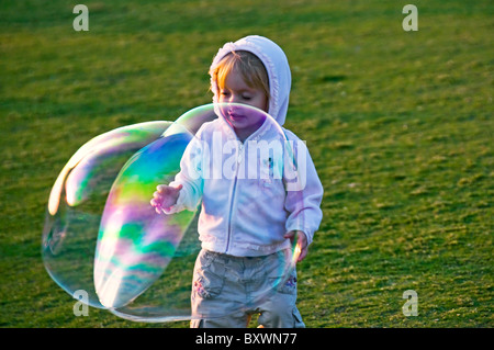 Kleine Mädchen beobachten riesige Seifenblase Stockfoto