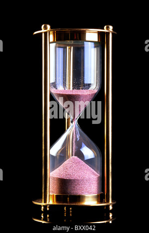 Ein Messing-Sanduhr oder Sand Timer auf schwarzem Hintergrund isoliert. Stockfoto