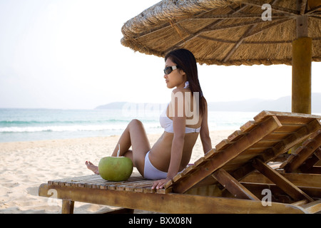 Entspannende junge Frau am Strand Stockfoto