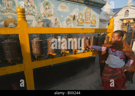 Pilger dreht eine Gebetsmühle an der tibetisch-buddhistischen Stupa von Boudhanath in Kathmandu. Stockfoto