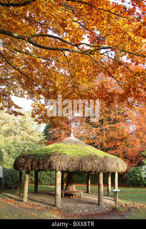 Nachlass von Tatton Park, England. Herbstliche Ansicht Tatton Park strohgedeckten afrikanischen Hütte. Stockfoto