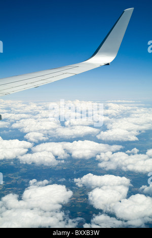 Flügel der Boeing 737-800 fliegen über den Wolken am blauen Himmel Stockfoto