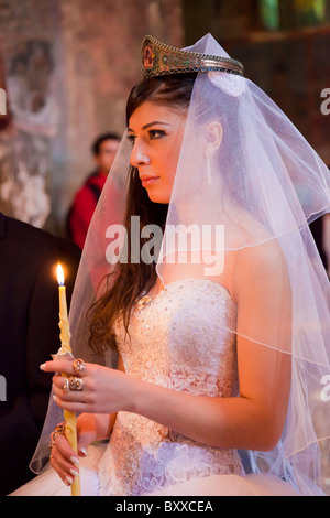 Schöne Braut hält beleuchtete Kerze am georgischen Hochzeitsservice in Sveti Tskhoveli Cathedral Mzcheta, Georgia. JMH4133 Stockfoto