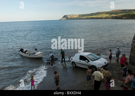 Ein kleines Fischerboot startet in Robin Hoods Bay, Yorkshire, Großbritannien Stockfoto