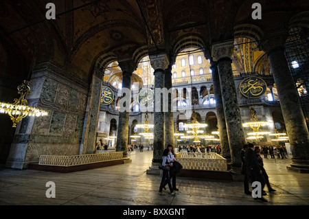 ISTANBUL, Türkei – die große Haupthalle der Hagia Sophia zeigt ihr bemerkenswertes byzantinisches Architekturdesign mit ihrer massiven zentralen Kuppel, die von Pendentiven und Halbkuppeln gestützt wird. Das Innere zeigt sowohl christliche als auch islamische Elemente, darunter byzantinische Mosaike, osmanische Kalligrafie und große osmanische Vogelleuchter. Massive Marmorsäulen und -Tafeln säumen den Raum und demonstrieren die Pracht der architektonischen Technik aus dem 6. Jahrhundert. Stockfoto