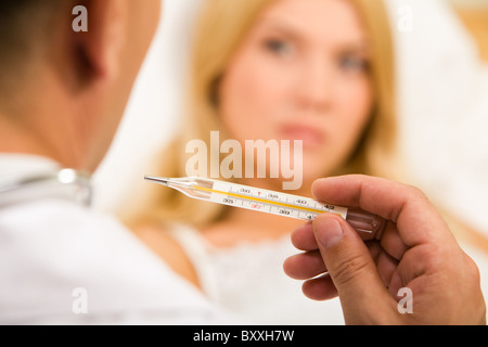 Nahaufnahme des Arztes Hand mit Thermometer mit kranke Frau auf Hintergrund Stockfoto