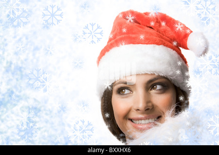 Gesicht lächelnde Frau in Santa Kappe aus Schneeflocken Stockfoto