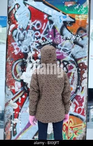 Ein Blick auf einige Touristen erhalten Teile der Berliner Mauer am Potsdamer Platz in Berlin, Deutschland. Stockfoto