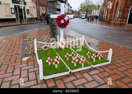 Memorial Mohnblumen auf Kreuze, gepflanzt im Rasen vor ein einfaches Kreuz, Wokingham, Berkshire. Stockfoto