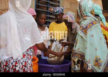 In Ouagadougou, Burkina Faso, Fulani Frauen zusammenarbeiten, um eine traditionelle Hirse-Getränk für ein Baby Taufe Party zu machen. Stockfoto