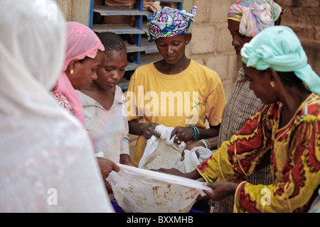 In Ouagadougou, Burkina Faso, Fulani Frauen zusammenarbeiten, um eine traditionelle Hirse-Getränk für ein Baby Taufe Party zu machen. Stockfoto